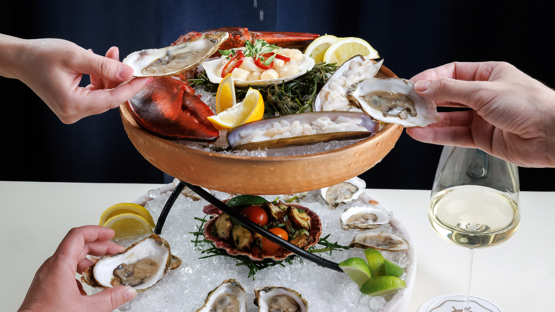 a group of hands holding a bowl of food