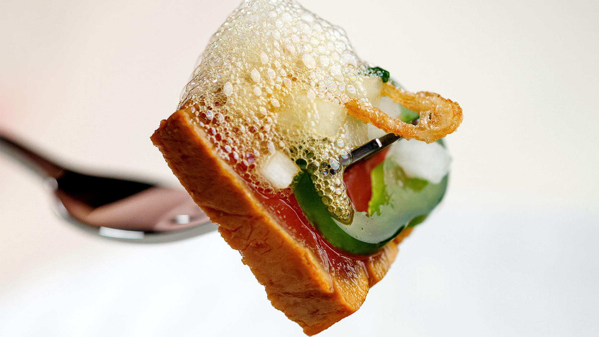 a piece of bread with a piece of food covered in bubbles