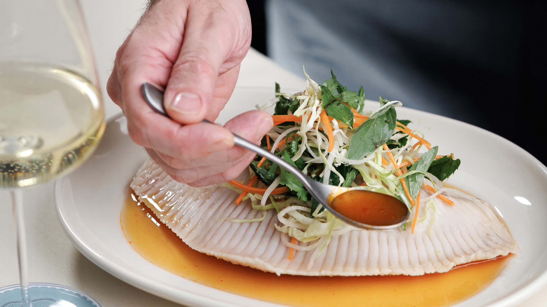 a person holding a spoon over a plate of food