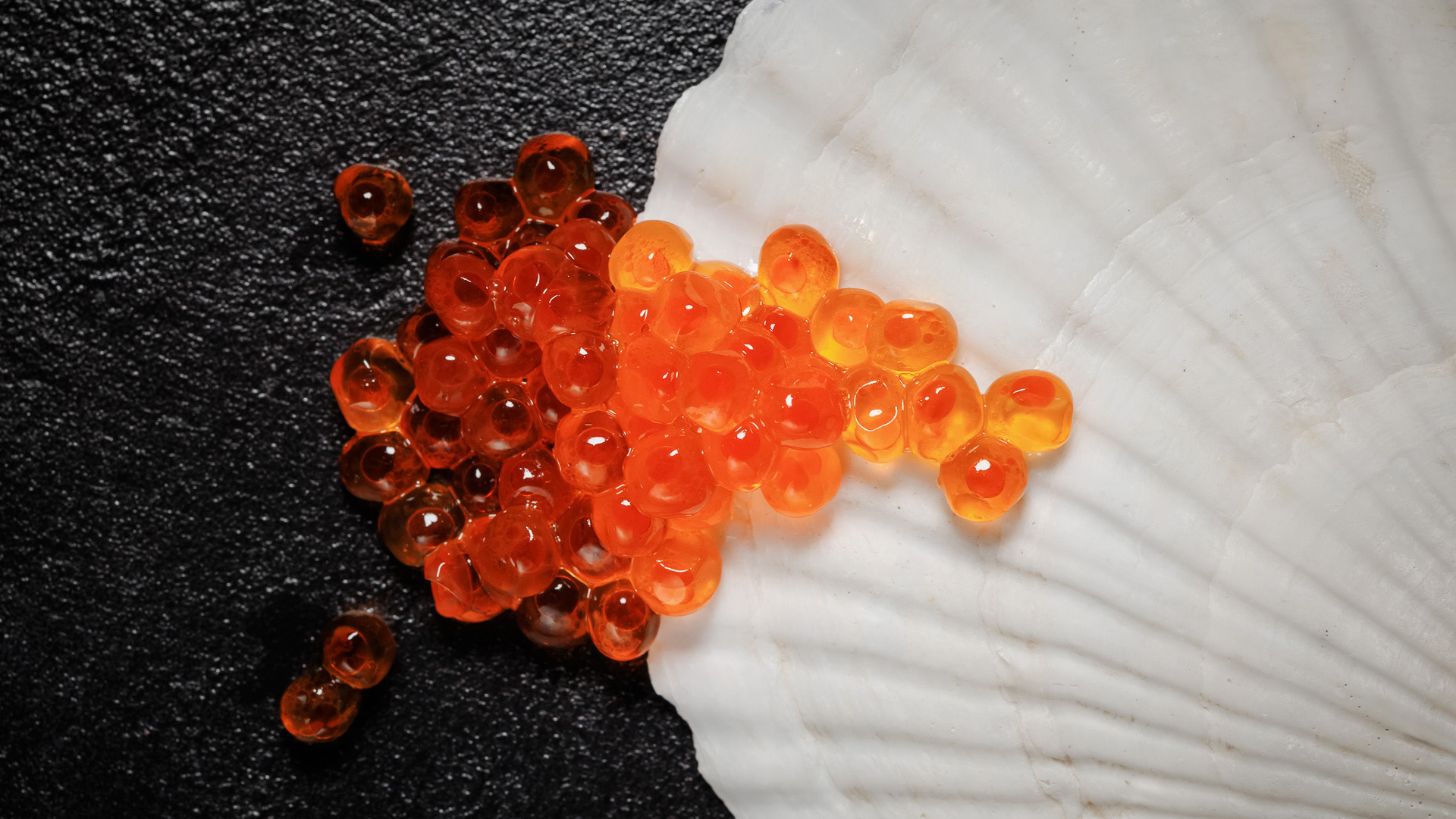 a group of orange eggs on a white shell