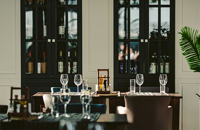 a table with wine glasses and bottles in the background