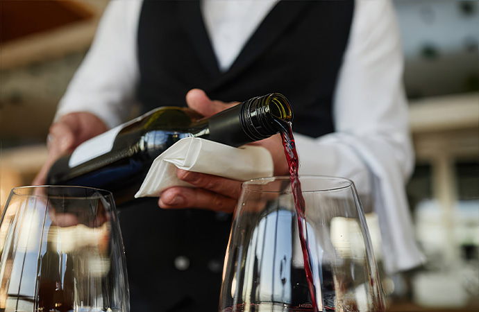 a person pouring wine into a glass