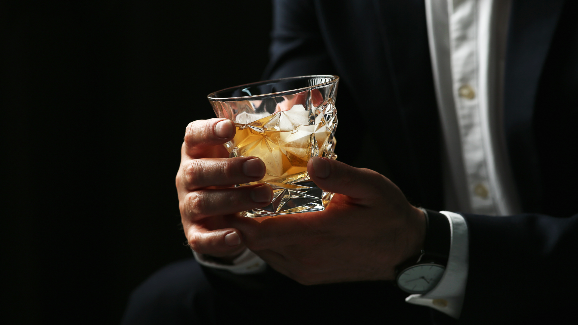 a person holding a glass of alcohol