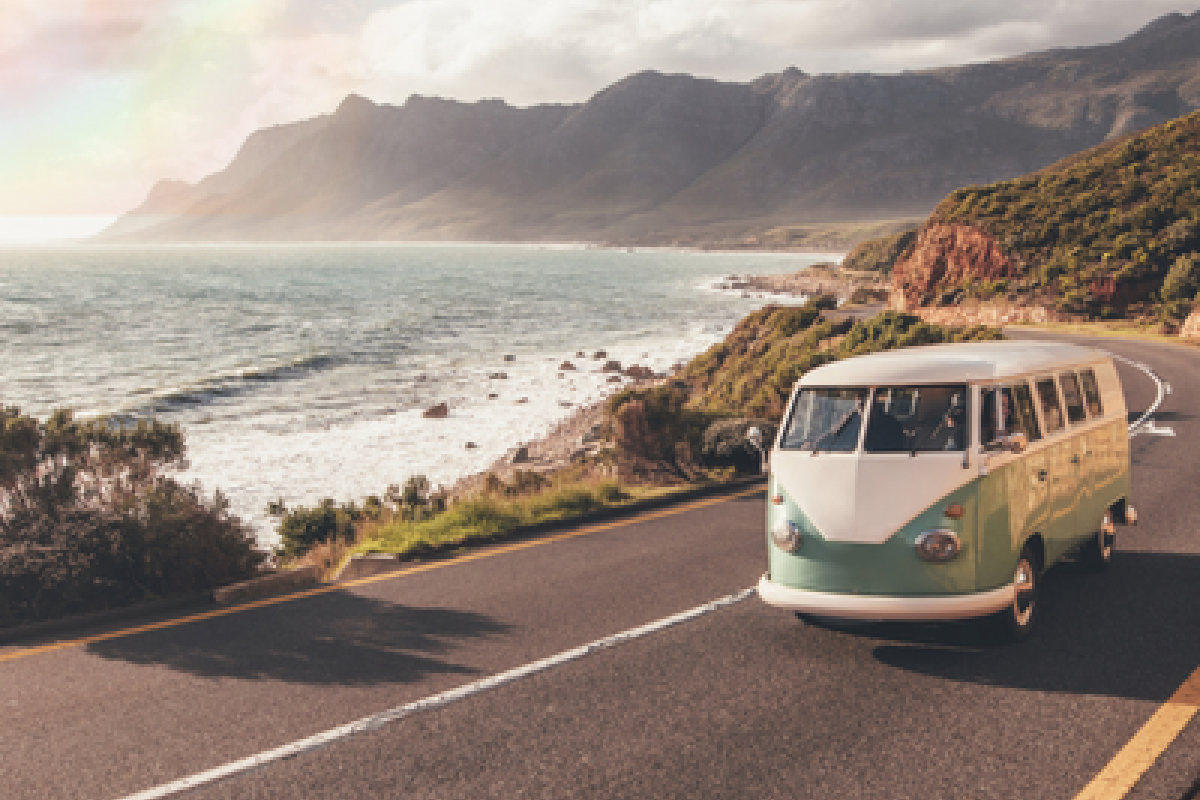 a van driving on a road by the ocean