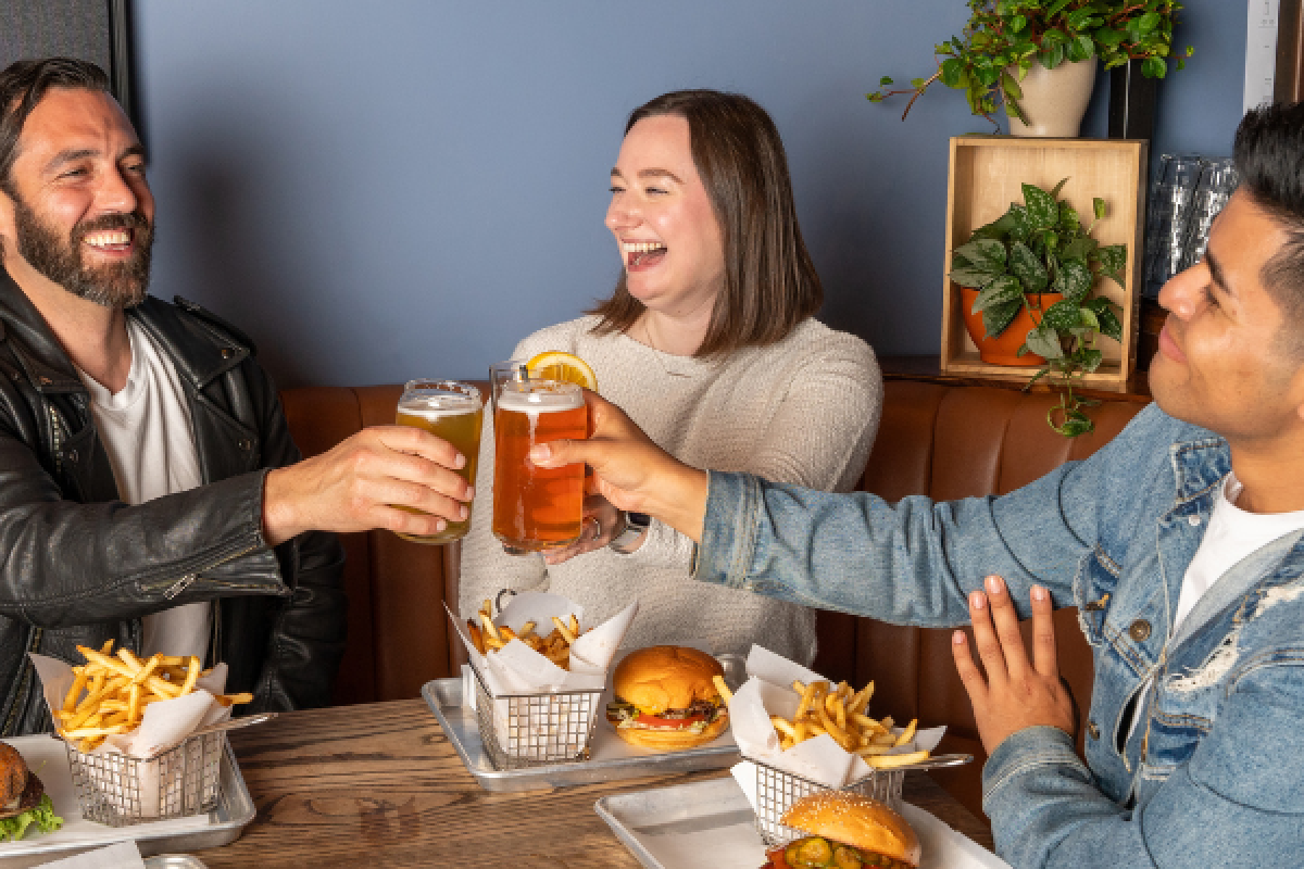 a group of people sitting at a table with food