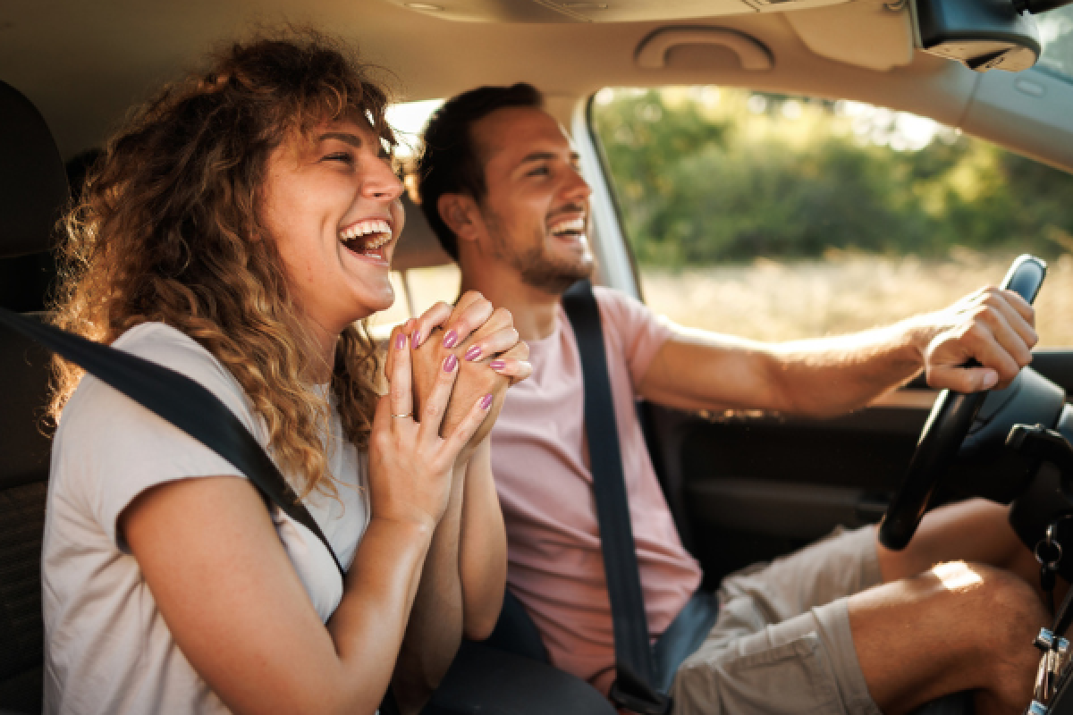 a man and woman in a car laughing