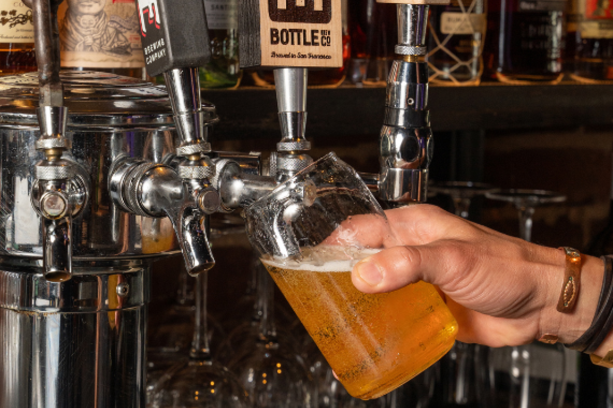 a hand holding a glass of beer