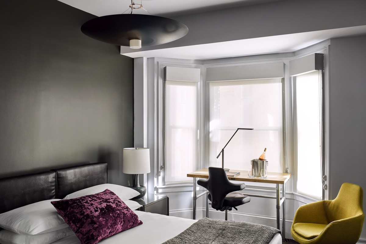 a bedroom with a bed and a desk and chair