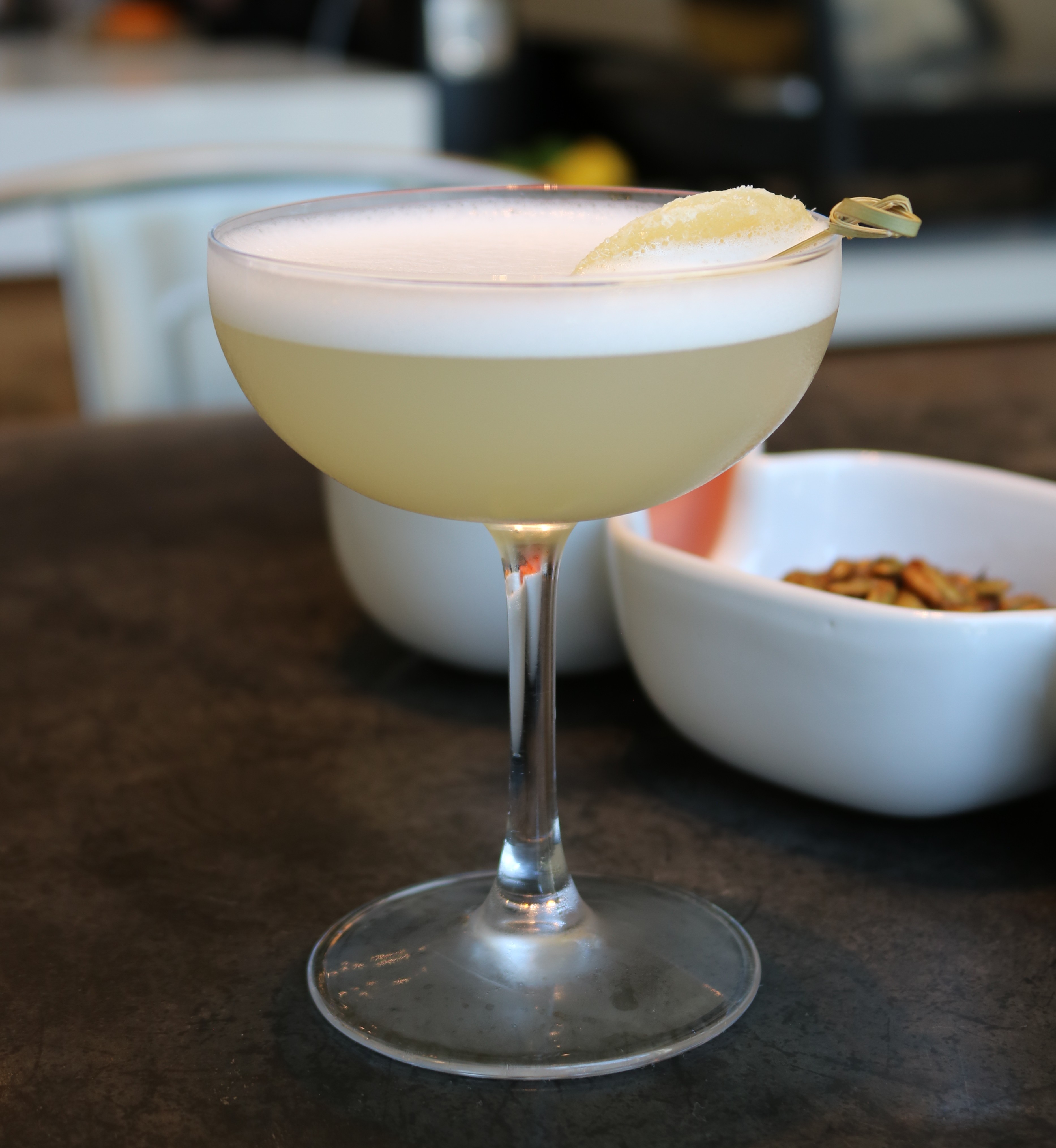 a glass of drink with a yellow liquid in it