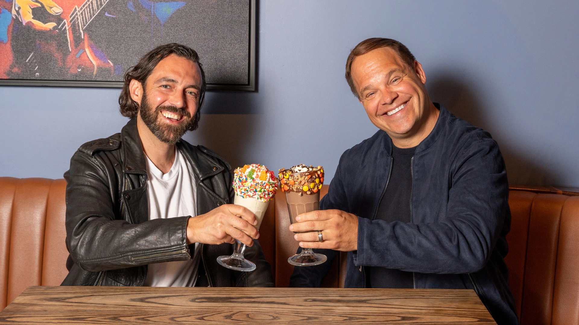 two men holding drinks with sprinkles