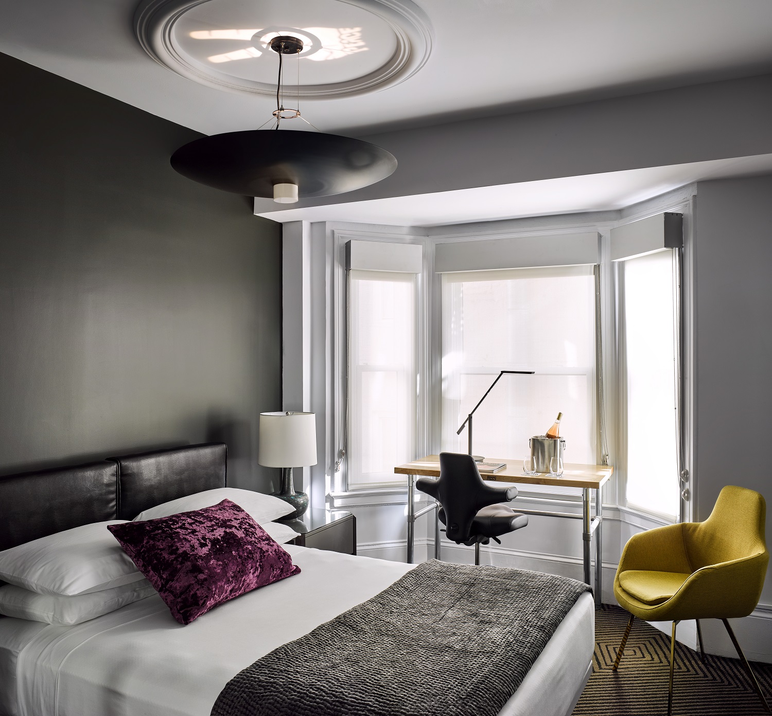 a bedroom with a bed and a desk and chair