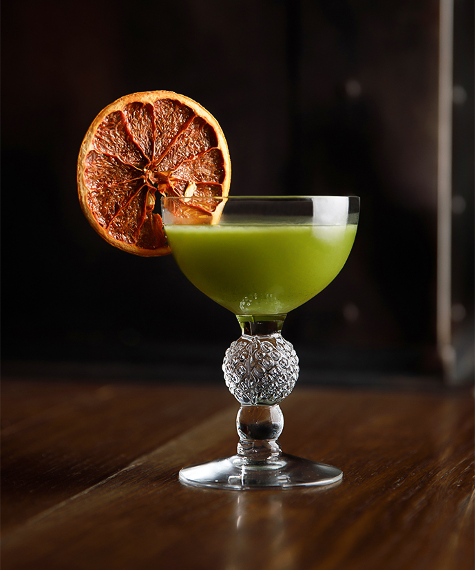 a glass with a drink and a slice of orange on it