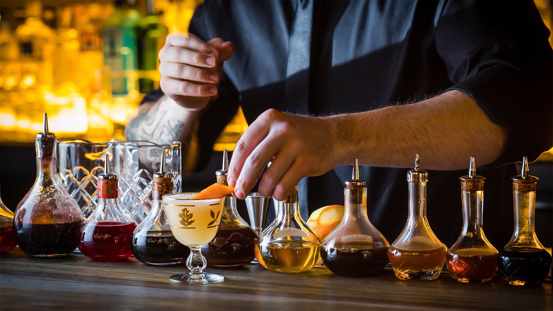 a person putting an orange peel into a glass