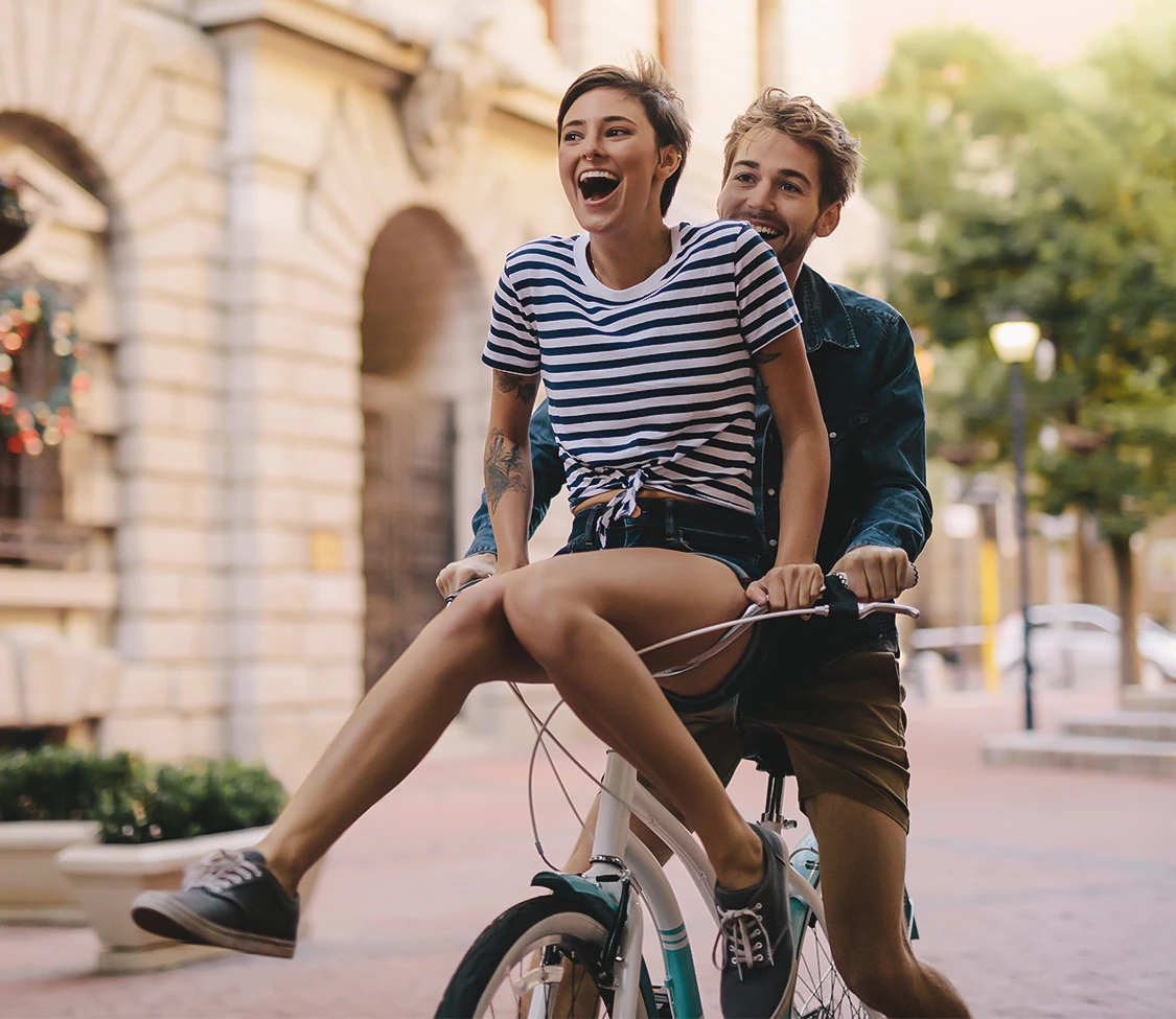a man and woman riding a bicycle