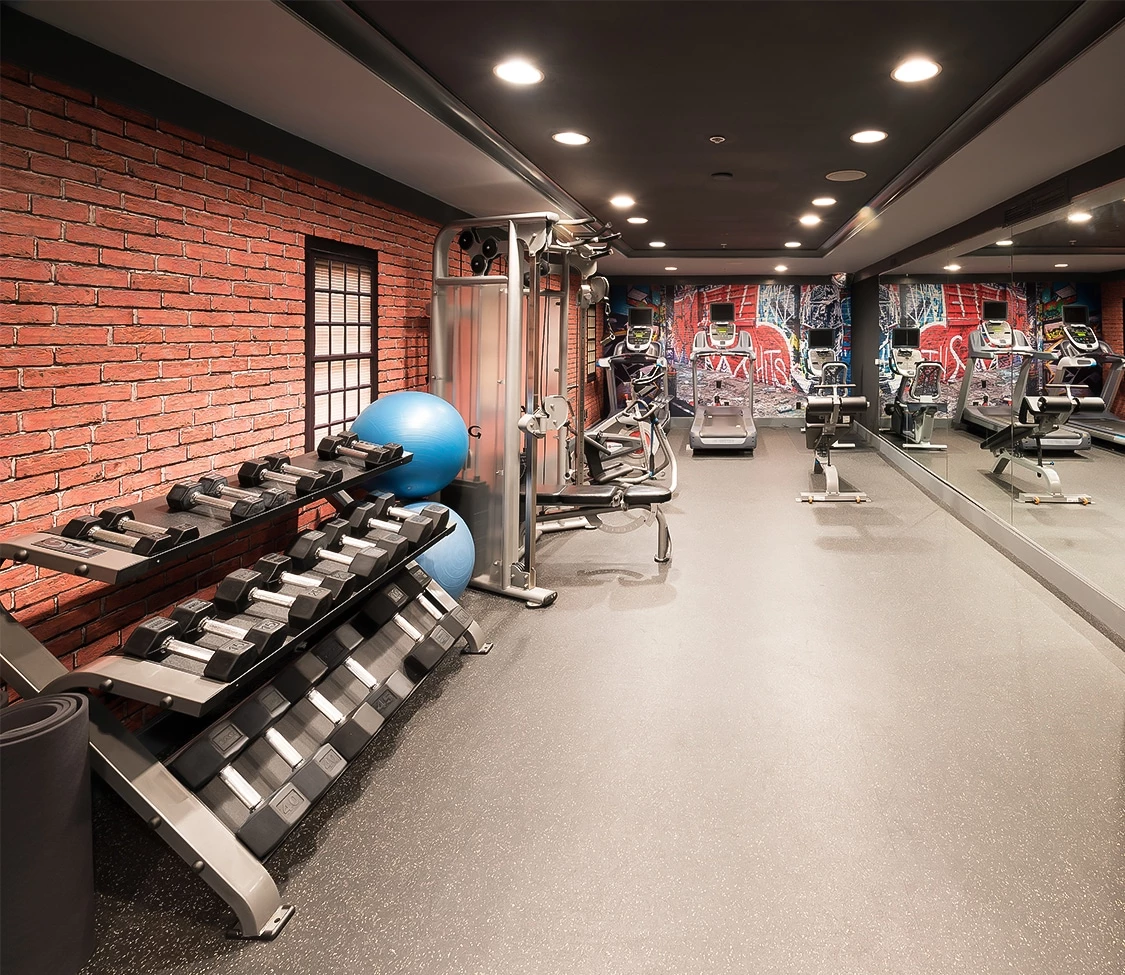 a room with exercise equipment and a brick wall