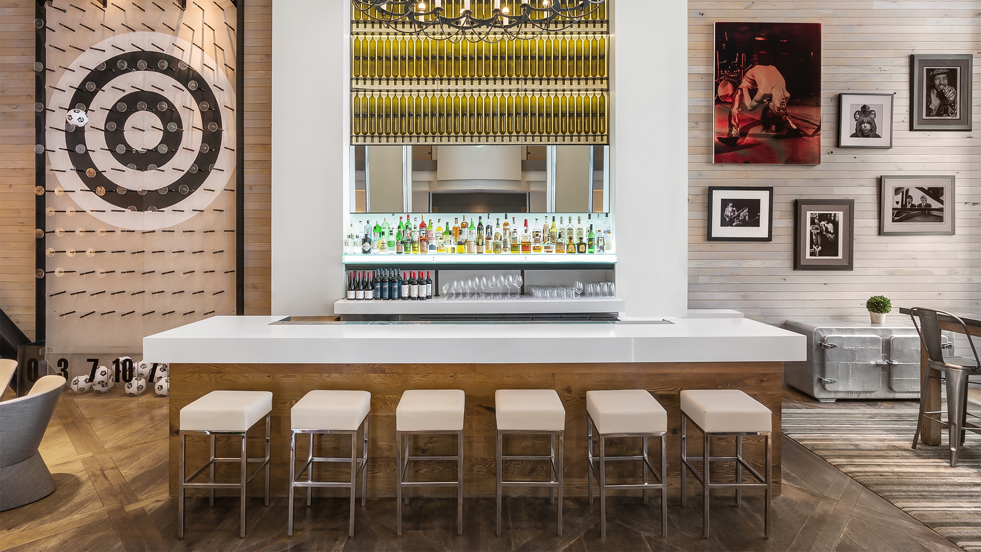 a bar with bottles of liquid and a mirror above it
