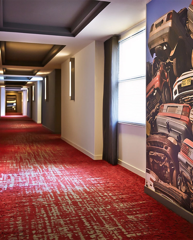 a long hallway with a painting of cars on the wall