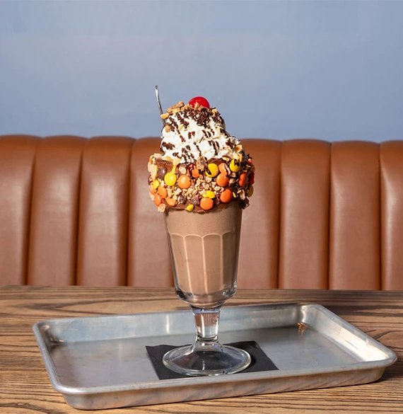 a chocolate milkshake with a cherry on top