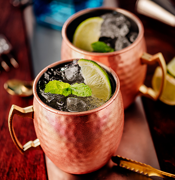 two copper mugs with ice and lime slices