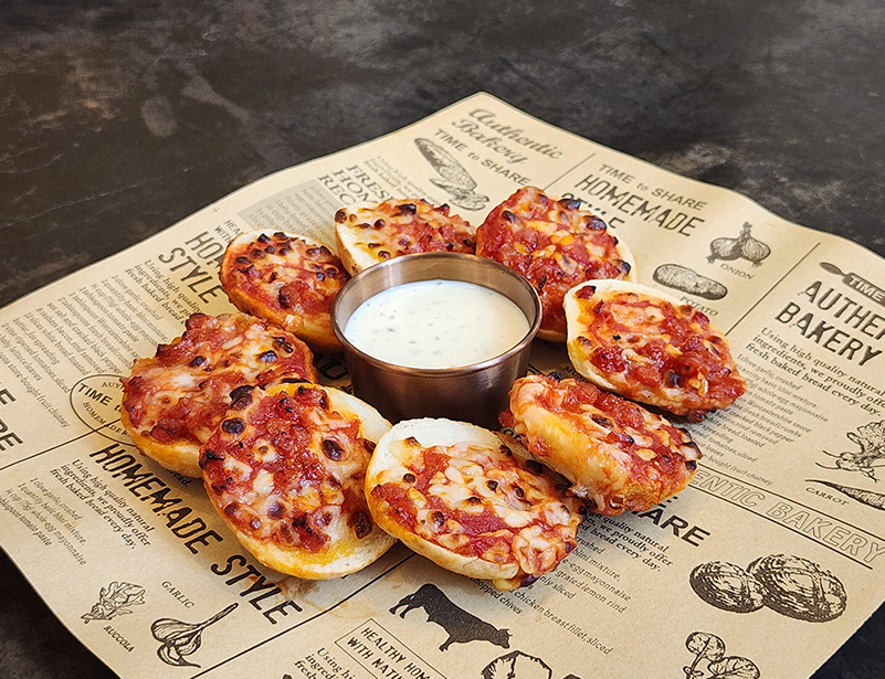 a small pizzas on a newspaper