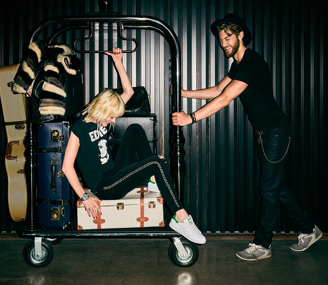 a man pushing a woman on a luggage cart
