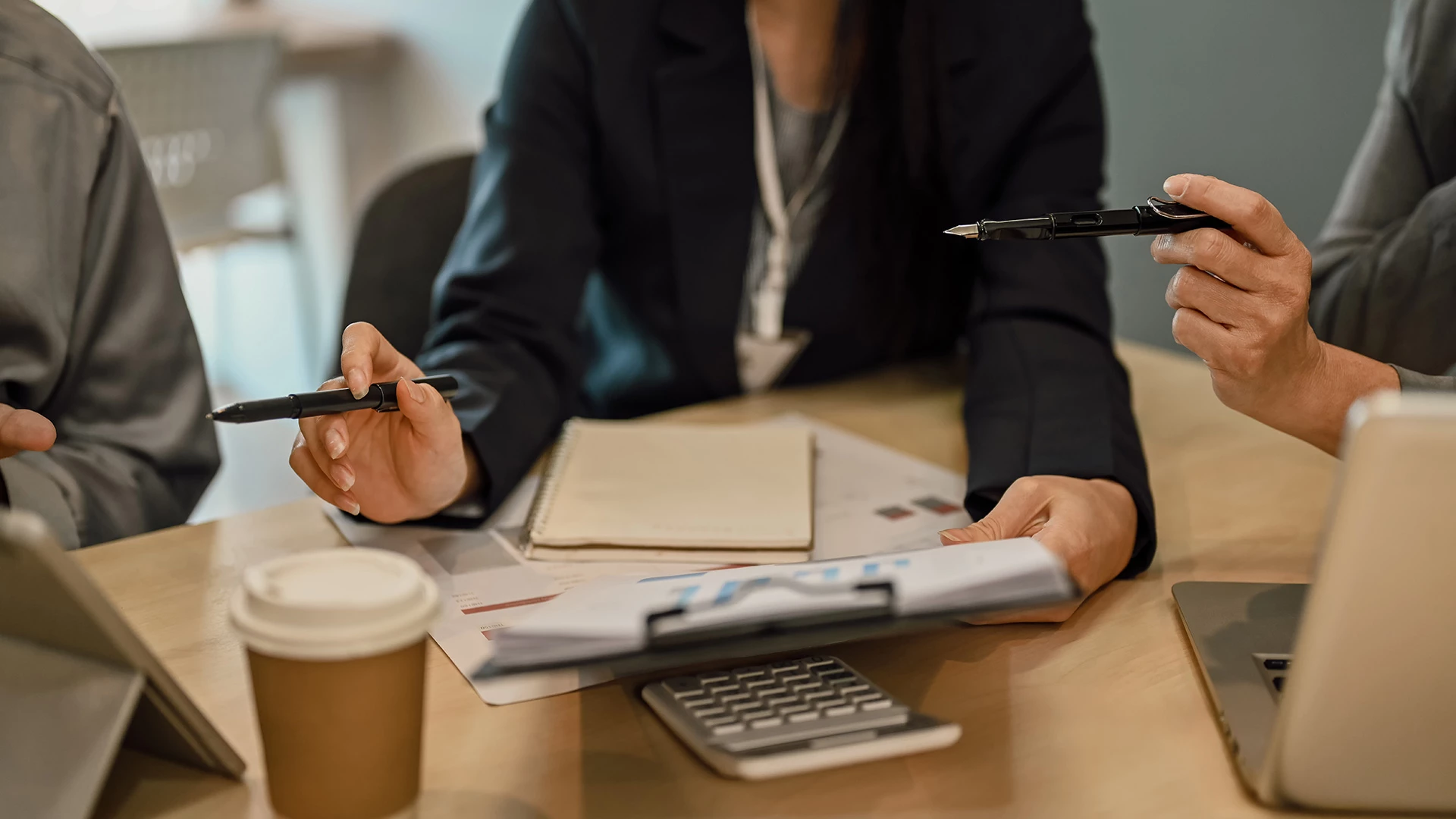 a woman sitting at a table with a pen and a notebook
