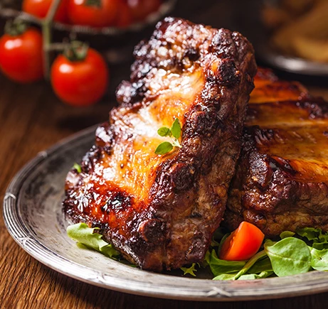 a plate of ribs and tomatoes