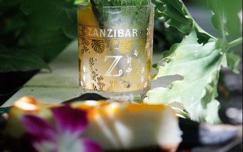 a drink in a glass with a plant on it