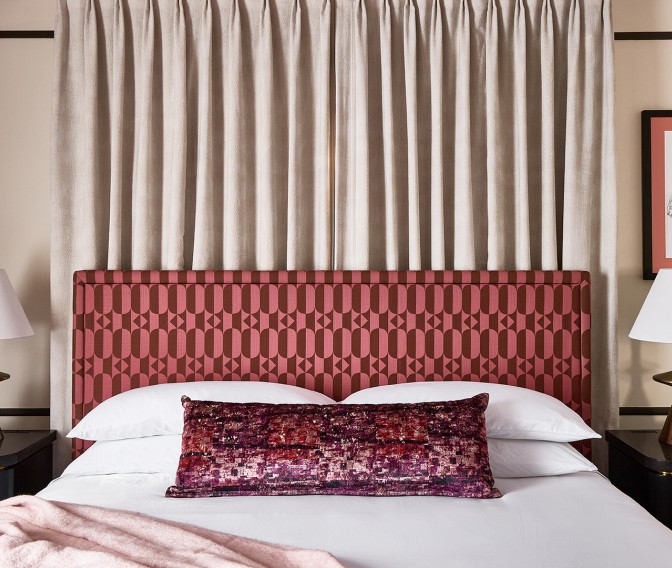 a bed with a red headboard and a pillow