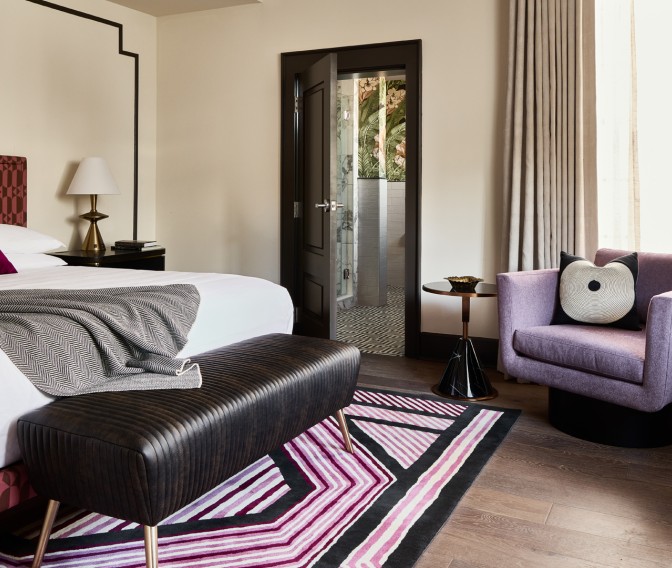 a bedroom with a bed and purple couch