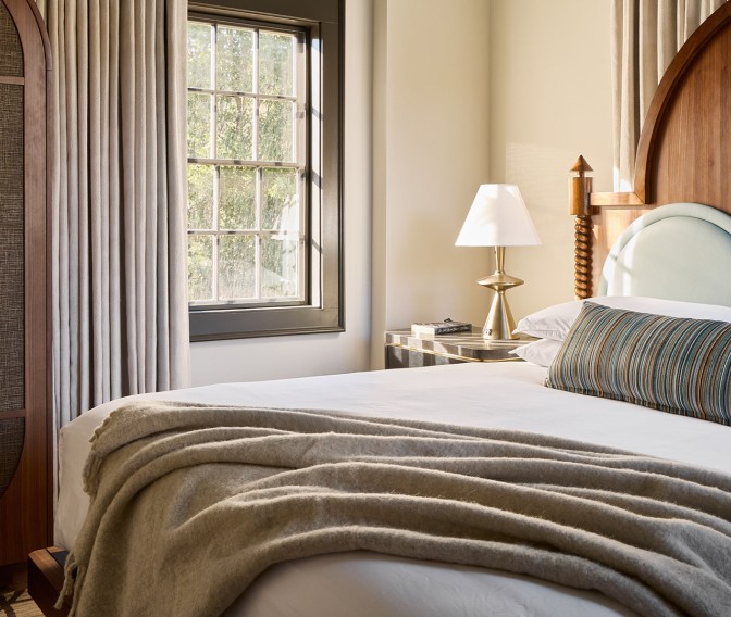 a bed with a lamp and a window