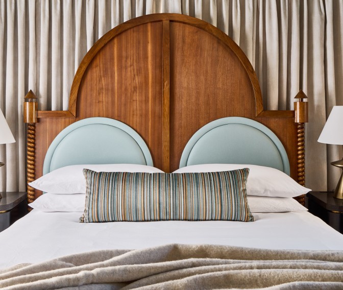 a bed with pillows and a wooden headboard