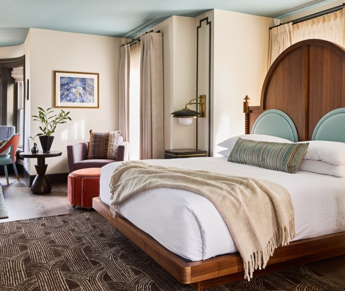 a room with a bed and chairs