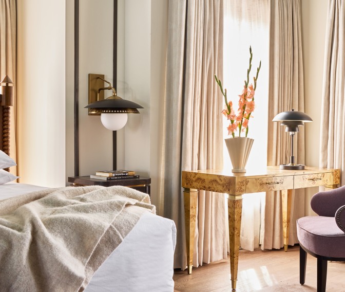 a room with a table lamp and a vase of flowers