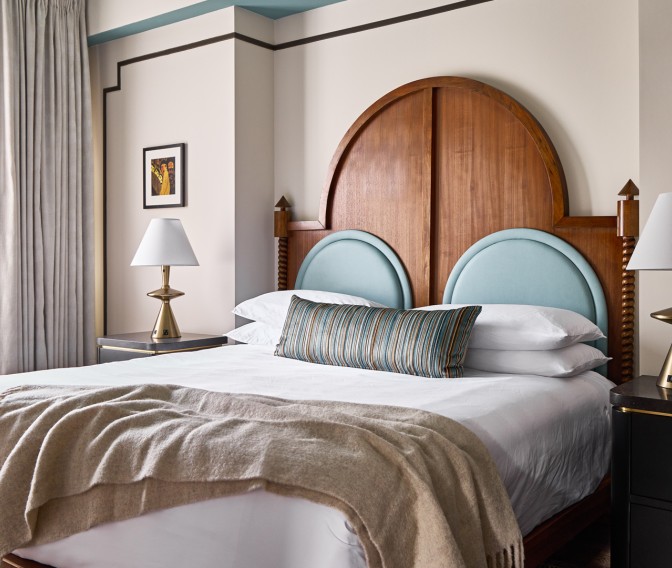 a bed with a wood headboard and a lamp