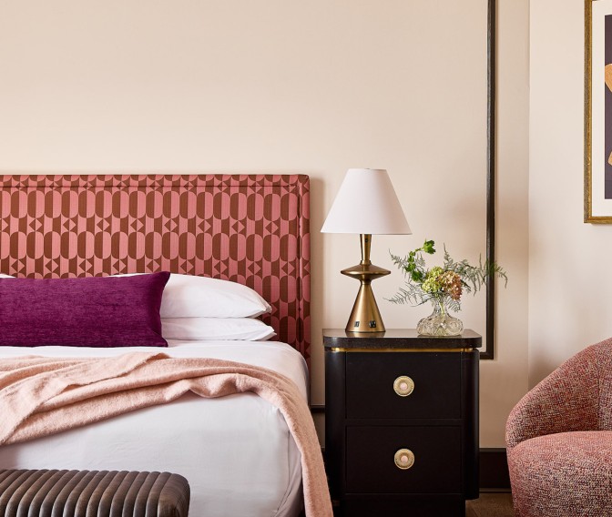 a bed with a lamp on a table