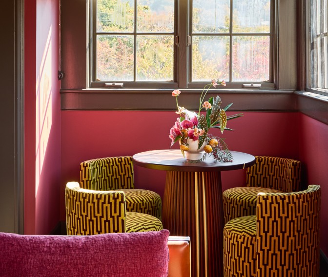 a table with chairs and a vase of flowers