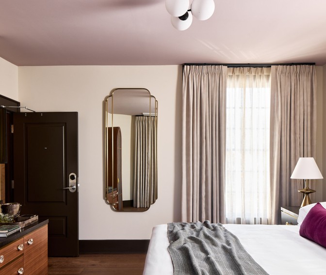 a bedroom with a mirror and a bed