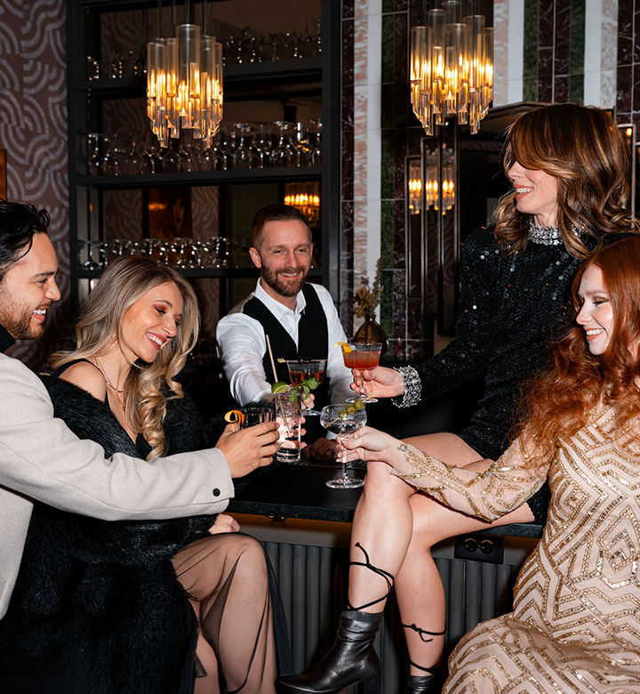 a group of people sitting at a bar with drinks