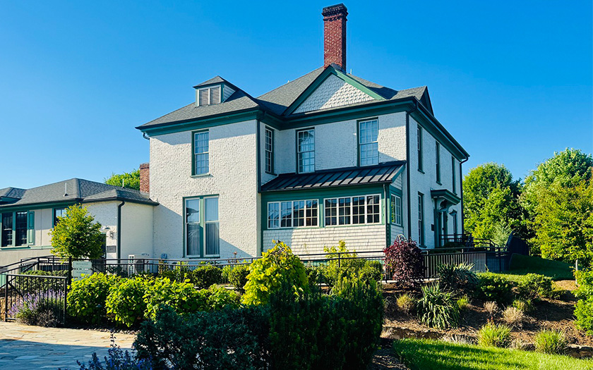 a large white house with a green roof