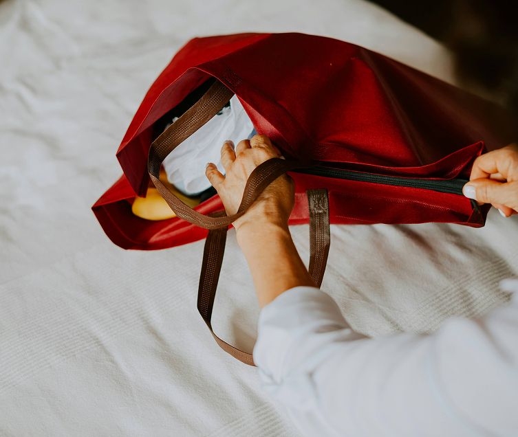 a hand holding a red bag