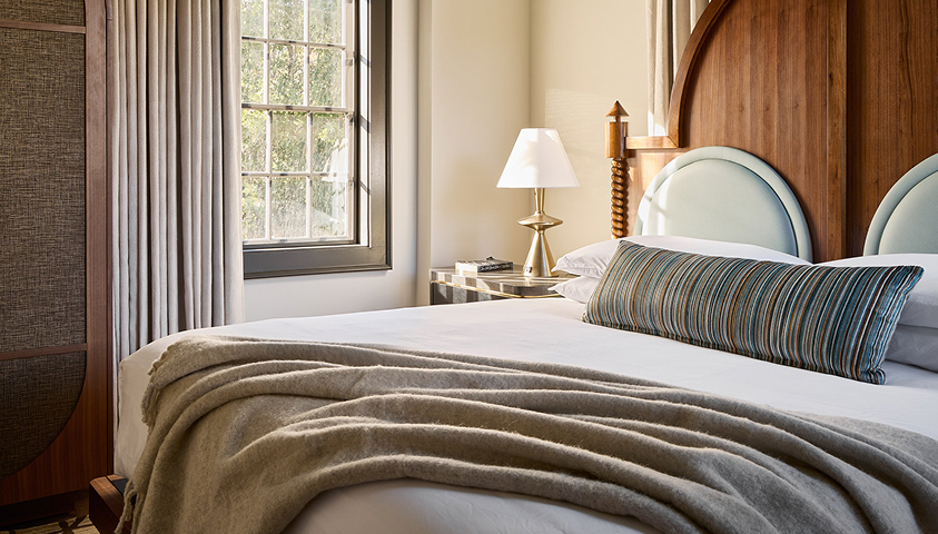 a bed with a lamp and a window