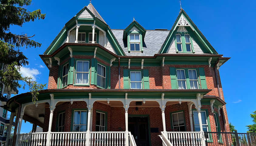 a house with green shutters and white railings