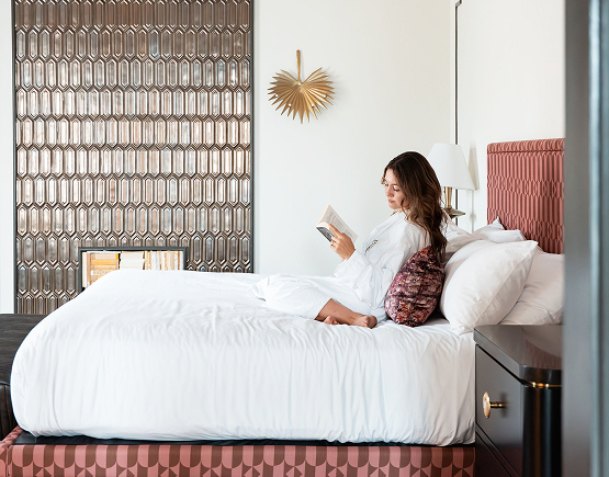 a woman reading a book on a bed