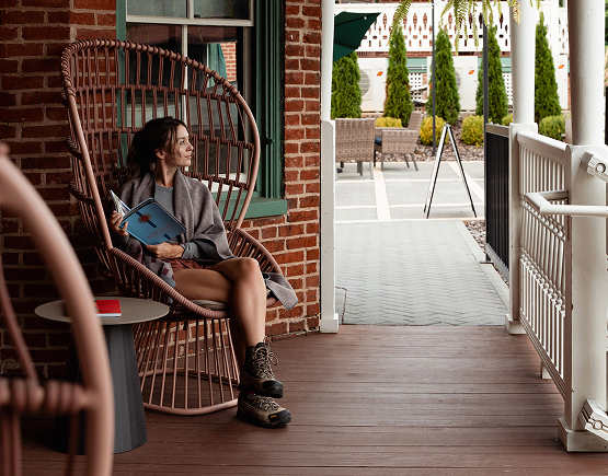 a woman sitting in a chair on a porch