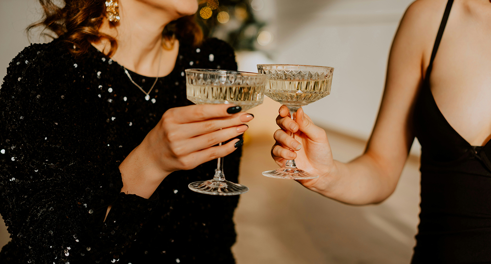 a pair of hands holding champagne glasses