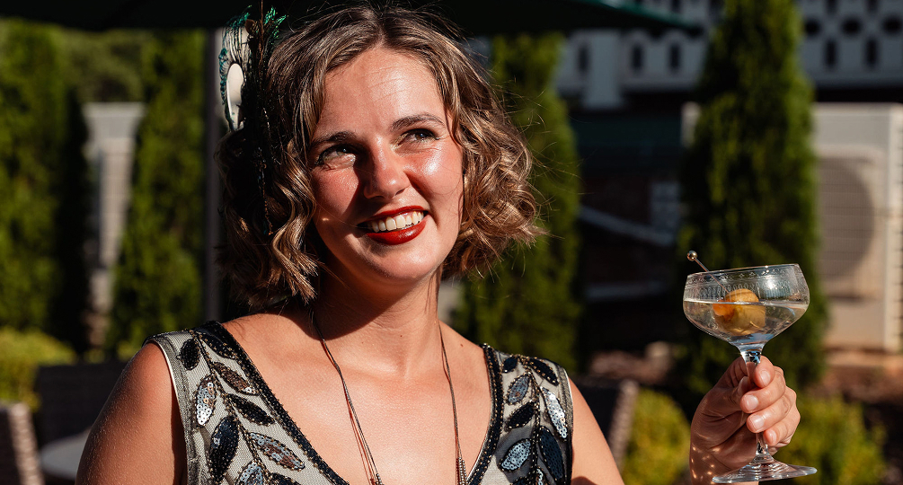 a woman smiling with a glass of wine