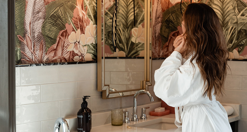 a woman in a white robe in front of a mirror