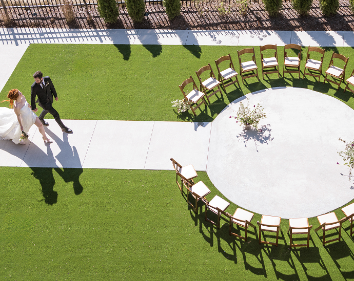 a man and woman walking down a path with chairs around them