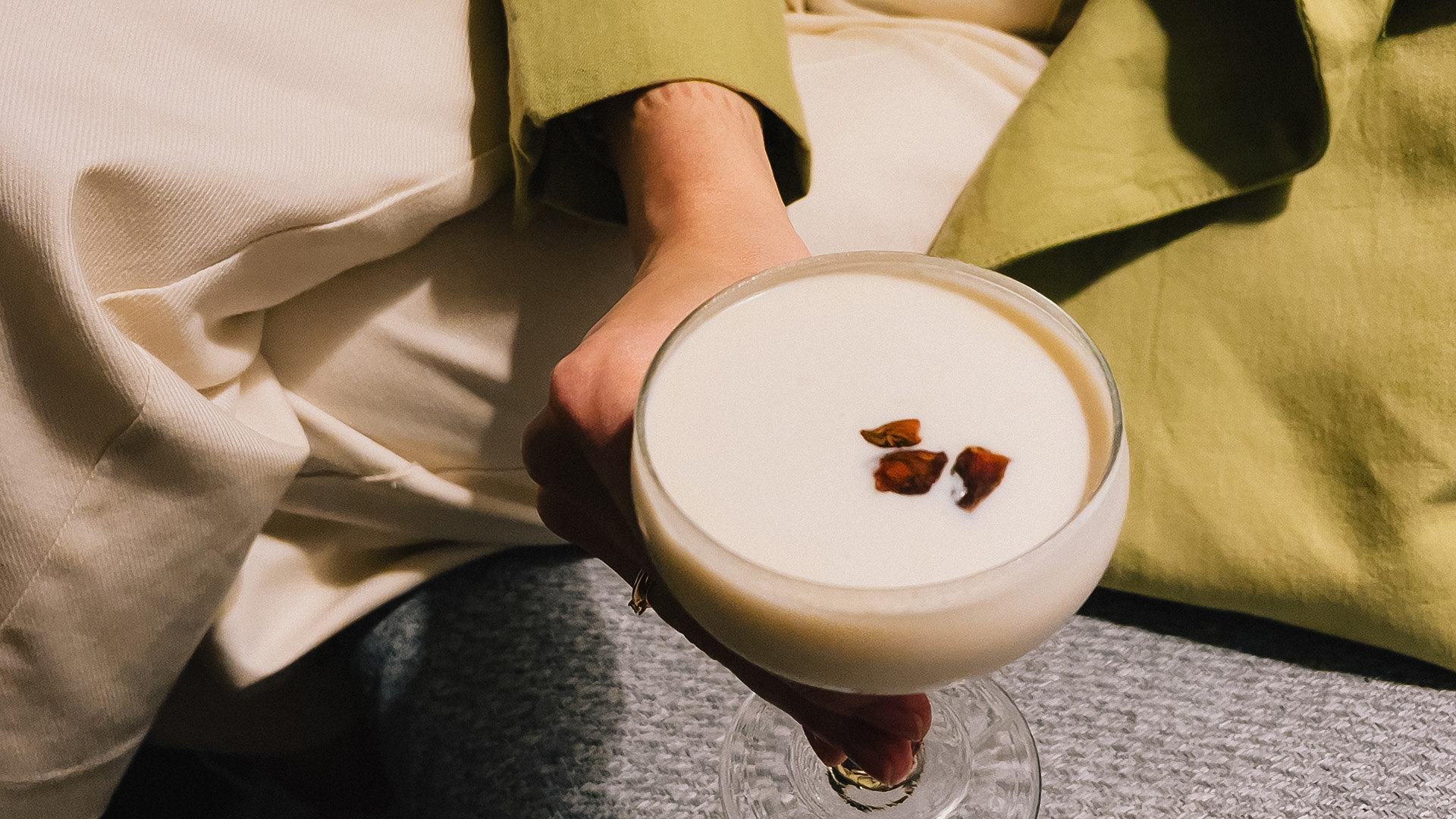 a hand holding a glass of liquid